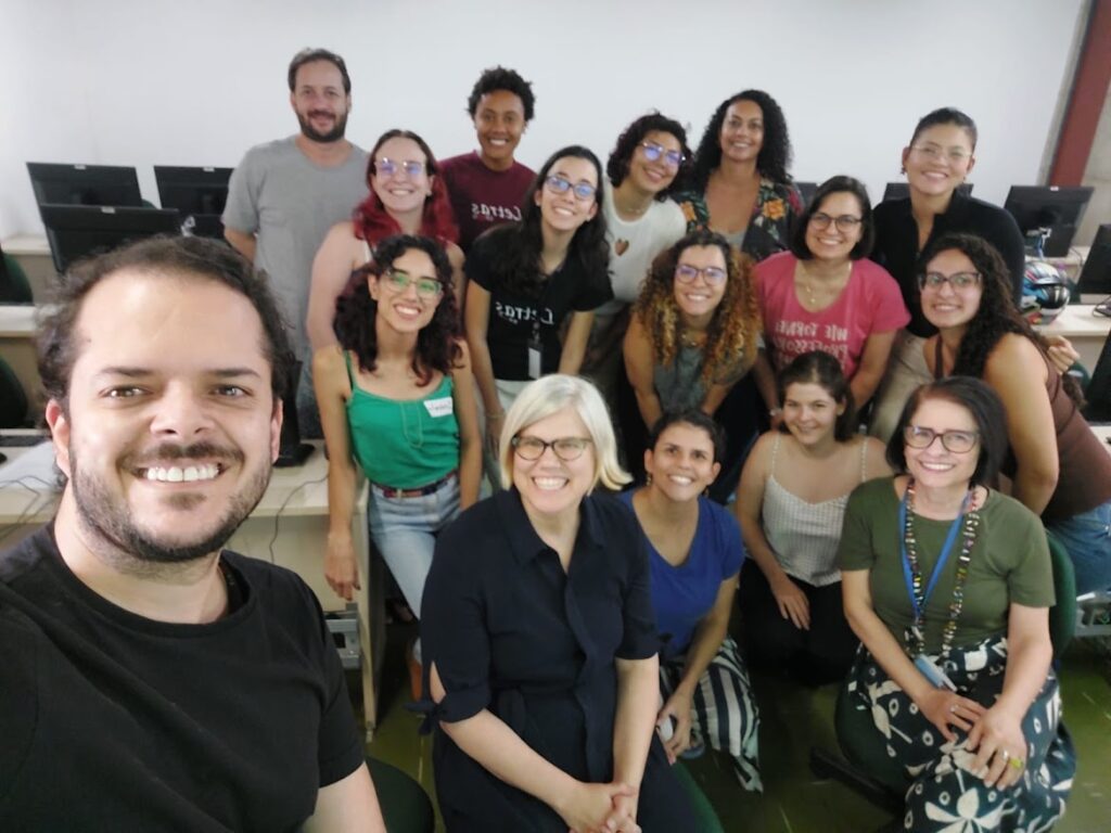 Group photo with Dr. Shelley Staples at UFMG. Full of grinning faculty and participants and, to Dr. Staples' right, near the front is Dr. Deise Dutra.